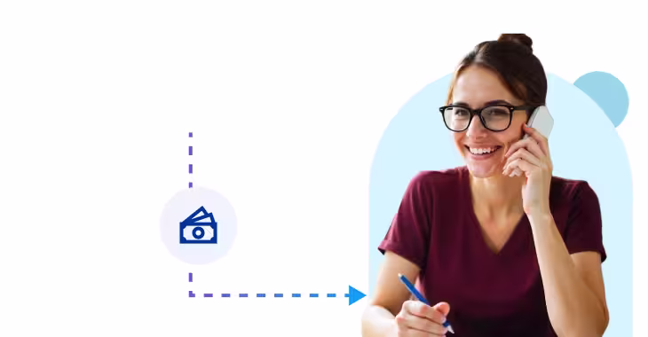 a smiling woman with glasses and her hair in a bun talking on a smartphone while holding a pen
